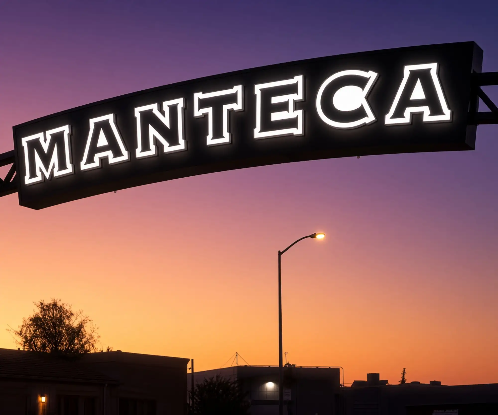 El letrero iluminado de Manteca sobre una calle al anochecer