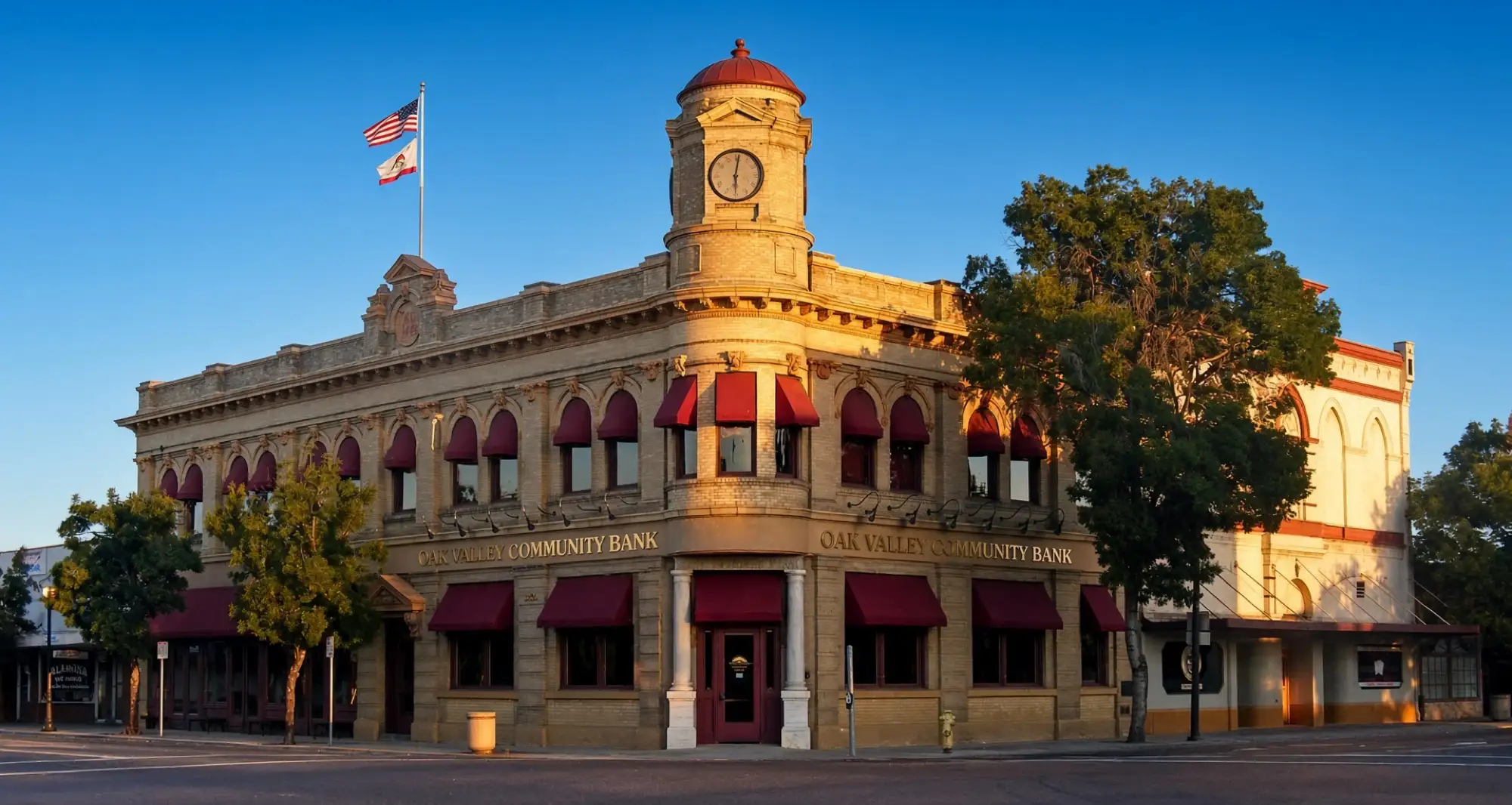 Un edificio histórico de banco con cúpula en una esquina del centro de Oakdale al atardecer