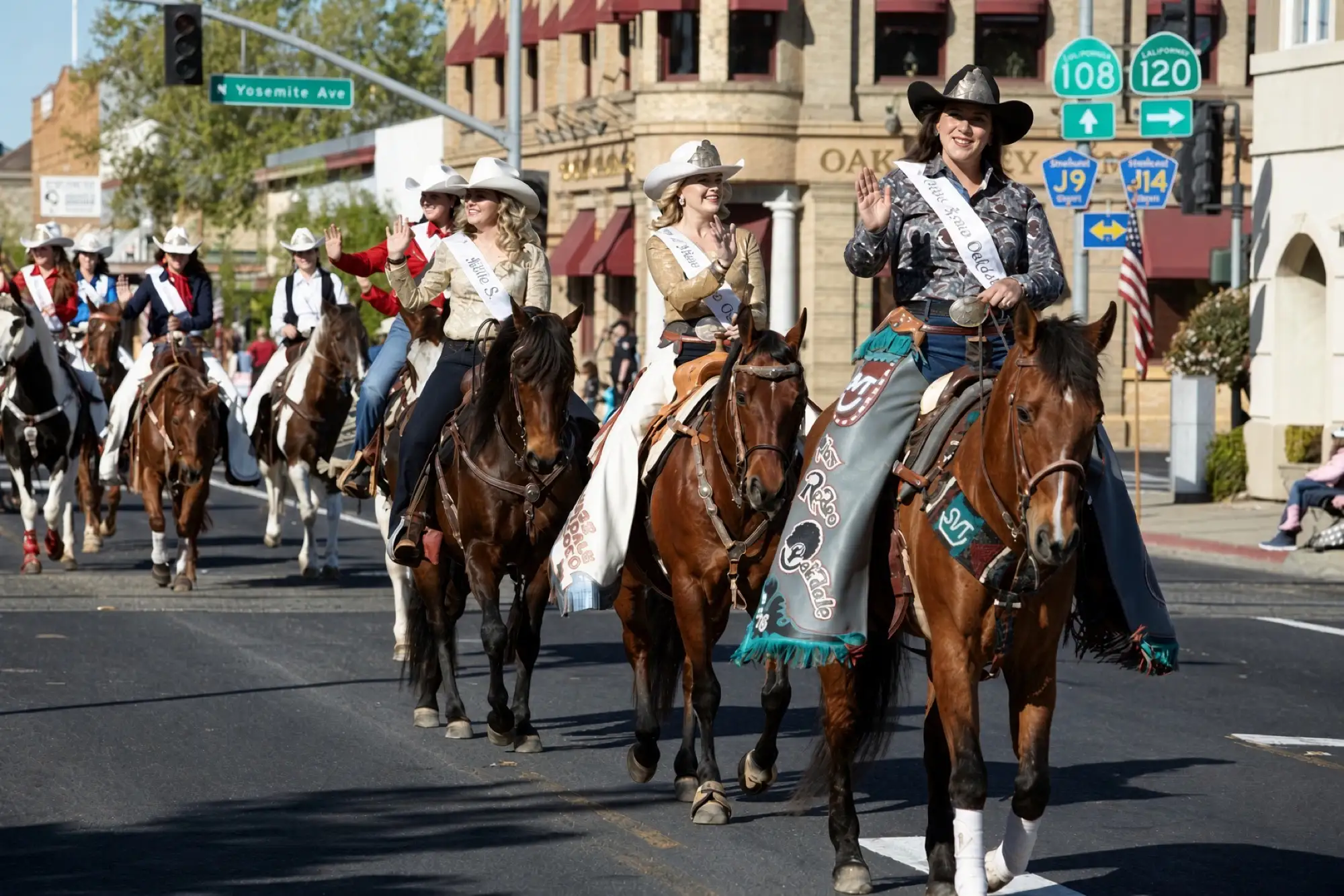 Reinas del rodeo a caballo en un desfile por el centro de Oakdale