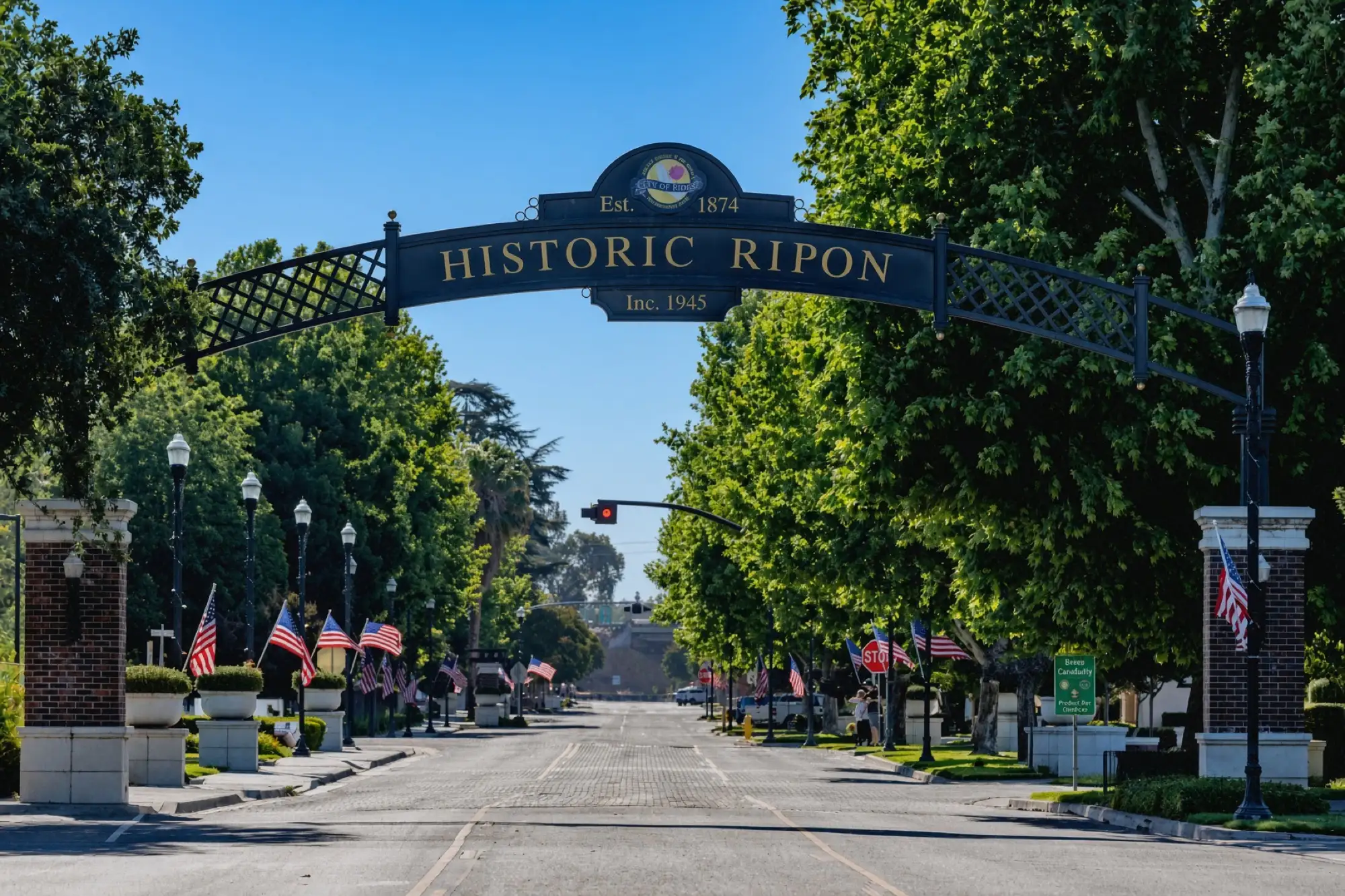 El arco de Historic Ripon sobre una calle principal con árboles y banderas